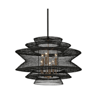 A black, circular patterned pendant lamp with brass bulb holders, with a contemporary design.