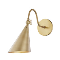 A gold-colored wall-mounted sconce with a perforated shade and a bowtie-shaped swivel key.