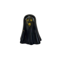 Black ghost figurine with yellow eyes on a white background