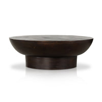 A round, vintage-style Salton coffee table with a dark, textured surface and a rounded mirrored edge.