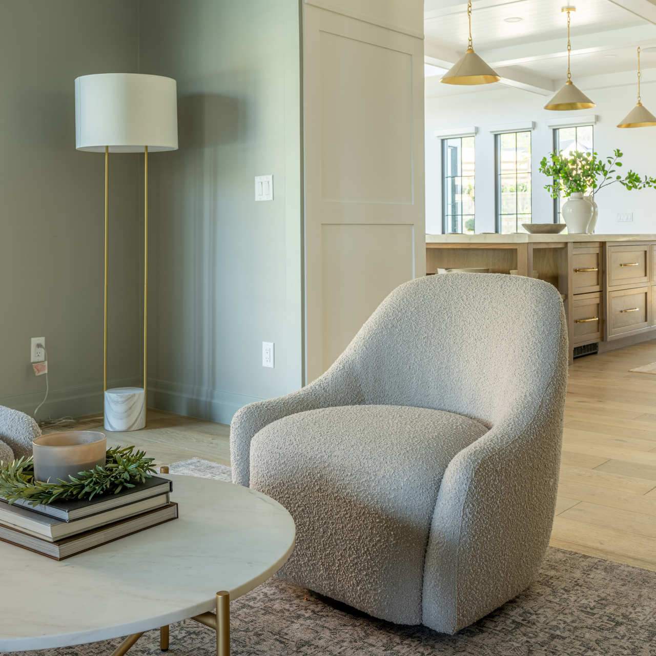 Modern living room with a gray armchair, round coffee table, and decorative elements.