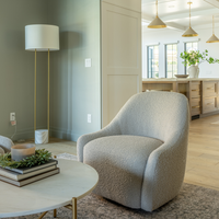 Modern living room with a gray armchair, round coffee table, and decorative elements.