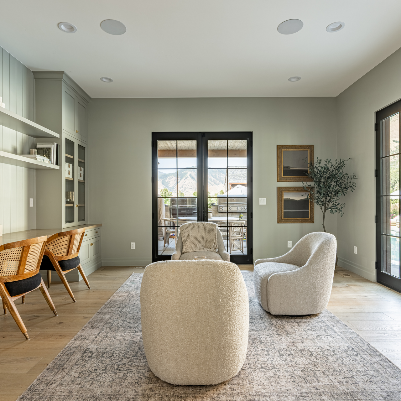 Modern living room with neutral furniture and large windows.