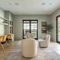 Modern living room with neutral furniture and large windows.