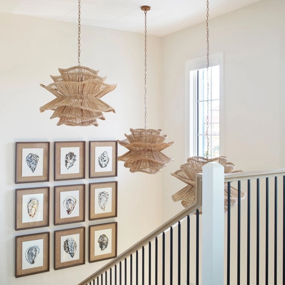 Staircase with framed artwork on the wall and decorative pendant lights.