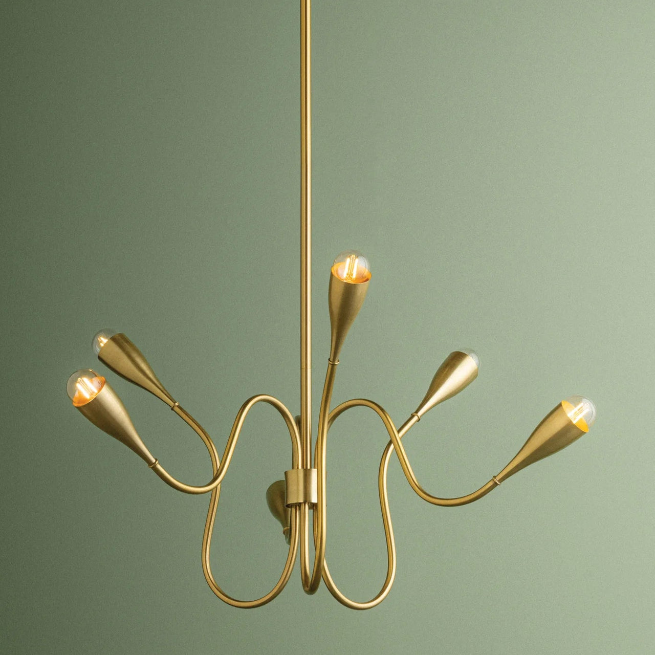 Gold chandelier against a green background
