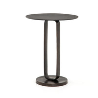 Round side table with a unique base design on a white background