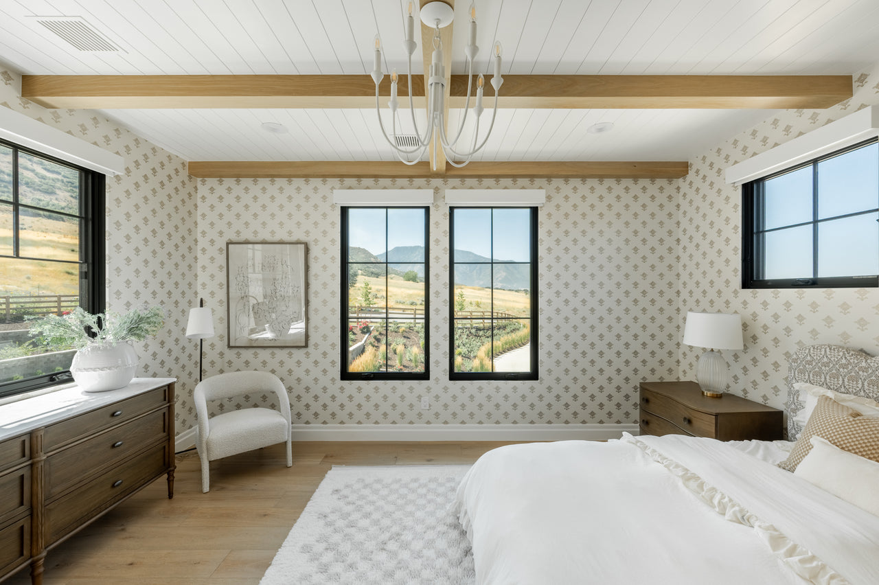 Modern bedroom with large windows, wooden beams, and decorative wall patterns.